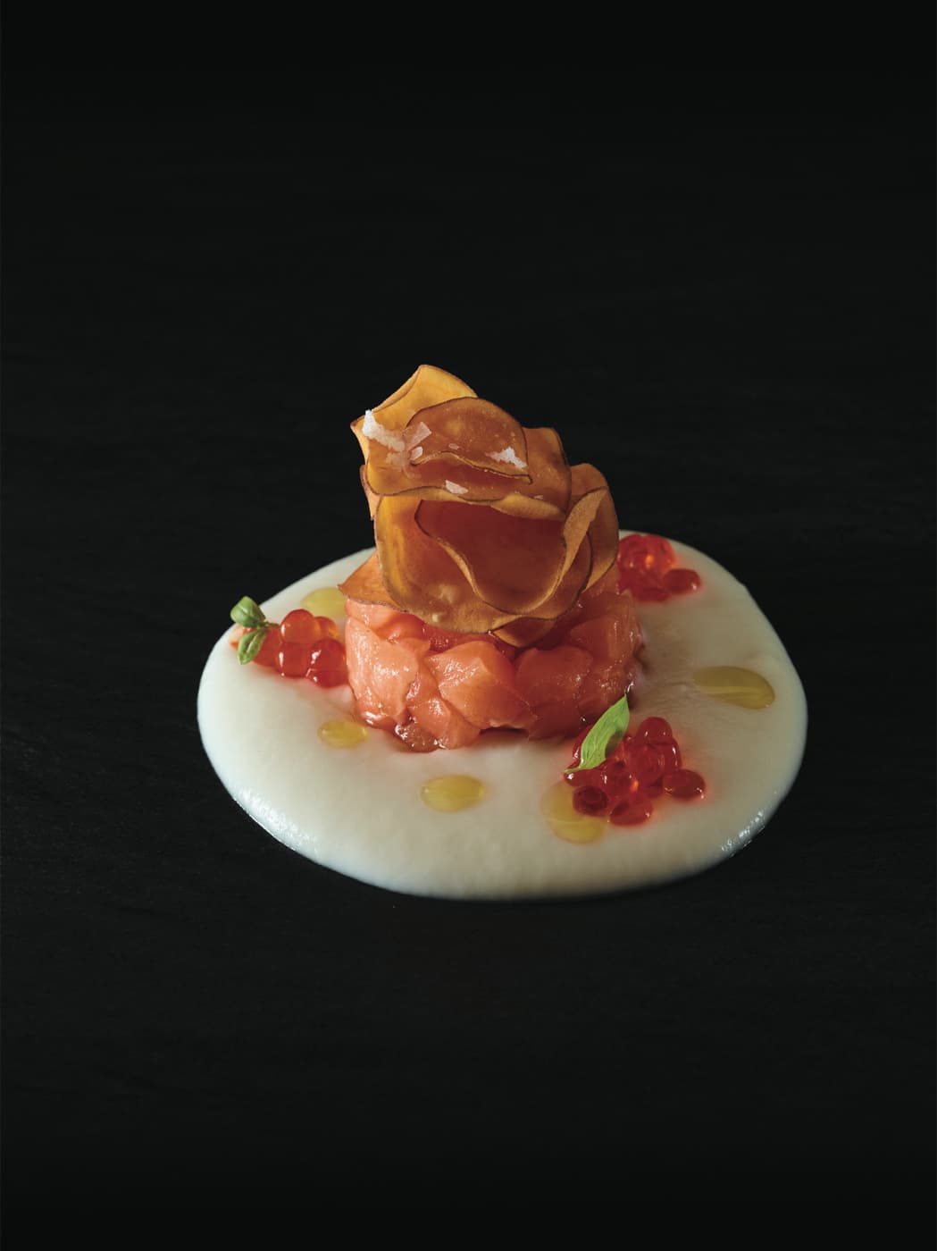 Patata morbida all'olio, tartare di salmone affumicato, le sue uova e basilico